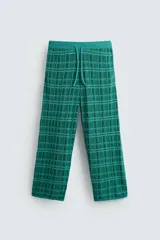 Pantalón relaxed fit de punto ligero tejido en hilatura con algodón, color verde con diseño a cuadros. Cintura elástica ajustable con cordón y bolsillos laterales.