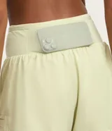 Bermuda deportiva femenina de microfibra color amarillo claro, con diseño de doble capa: un short interno ajustado y una capa externa suelta con bajo redondeado. Posee cintura alta.