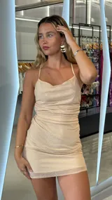 Minivestido color nude con brillos, escote halter, espalda descubierta con tiras cruzadas y falda ajustada.