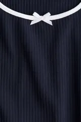 Vestido mini azul marino de manga corta en punto de algodón acanalado con pollera evasé. Modelo con cuerpo entallado y escote redondo amplio con ribete fino en color blanco y moña decorativa de satén. Ribete sobrehilado en mangas y bajo.