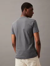 Remera gris de corte slim fit con cuello redondo y manga corta. Estampado frontal con el monograma de Calvin Klein Jeans en blanco y celeste.