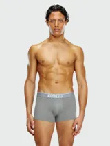 Pack de tres bóxers Diesel, uno gris liso con pretina gris claro con logo, y dos con estampados.