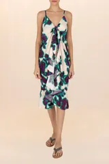 Vestido playero estampado con flores moradas y verdes, breteles finos y volados en el frente.