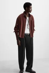 Pantalón negro de corte recto confeccionado en tejido fluido con mezcla de viscosa, con bolsillos frontales y traseros de vivo.