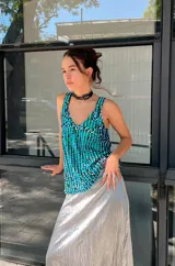 Musculosa con escote en V y breteles anchos, confeccionada en tela de lentejuelas color turquesa y verde.