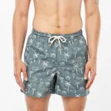 Short de baño celeste con estampado de palmeras blancas.