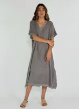 Vestido midi color amarillo, de corte suelto y manga corta, con ruedo desflecado.