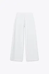 Pantalón de jean blanco, de tiro medio, corte wide leg y pinzas delanteras.