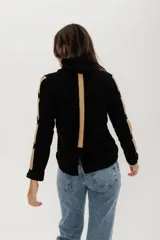 Buzo negro de punto en lanilla con diseño de ochos, corte tipo remera y cuello a la base.