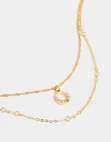 Collar corto doble dorado, con una cadena de eslabones y otra de eslabones retorcidos. La cadena más corta tiene circonitas engarzadas y la más larga tiene un dije circular con circonitas de colores.