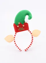 Vincha navideña con forma de gorro de duende verde y rojo, con orejas color piel a los costados. El gorro tiene detalles dorados y la frase 'Merry Christmas'. La vincha es a rayas rojas y blancas.