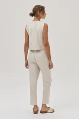 Pantalón chino de lino metalizado color beige, tiro medio-alto y pierna recta. Cuenta con bolsillos laterales y traseros.