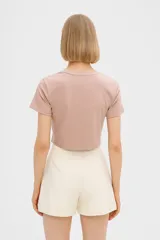 Remera cropped color rosa con estampado de conchas marinas en color rojo, corte holgado y cuello redondo.