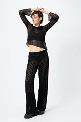 Pantalón de encaje negro con transparencias y cintura con elástico.