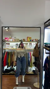 Top color crema con escote off-shoulder, mangas largas y detalle fruncido con cordones en el centro.