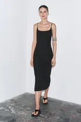 Vestido midi negro de breteles finos regulables, escote recto y abertura en el ruedo.