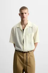 Camisa de hombre relaxed fit con cuello bowling y manga corta, confeccionada en tejido fluido con mezcla de viscosa a rayas verticales en tonos verde y blanco.