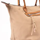 Bolso tipo shopper color beige con detalles en marrón. Tiene doble asa de hombro, cierre superior y bolsillo frontal con cierre.