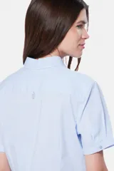 Camisa entallada de manga corta con rayas verticales celestes y blancas.