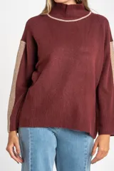 Sweater negro de tejido grueso con cuello alto acanalado. Presenta una franja decorativa en las mangas y el cuello en hilo marrón con brillo (lurex).