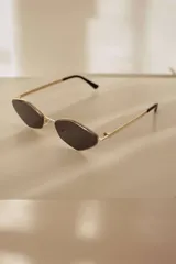 Lentes de sol con cristales oscuros de forma hexagonal y montura metálica fina en color dorado. Fabricados en policarbonato con protección UV400.