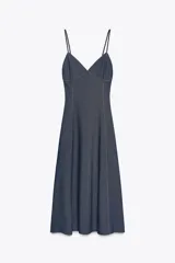 Vestido midi de denim azul con tirantes finos, escote en pico y pespuntes a contraste.