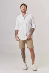 Camisa de hombre color crema, de corte clásico, con cuello abotonado y mangas largas.