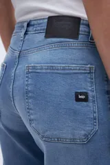 Pantalón jean celeste de corte holgado con pierna ancha y tiro alto. Tiene bolsillos delanteros y traseros, y cierre frontal con botones a la vista.