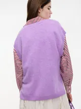 Chaleco sin mangas de cashmere color blanco, con escote en V y tajos laterales.
