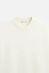 Sudadera negra de corte relaxed fit, confeccionada en tejido interlock de algodón con elasticidad. Tiene cuello redondo, manga corta y bajo acabado en rib.