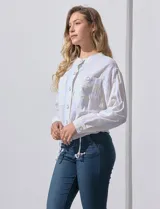 Chaqueta de lino a rayas verticales amarillas y celestes, con cuello a la base, abertura central con botones, bolsillos delanteros y ruedo con jareta de ajuste.