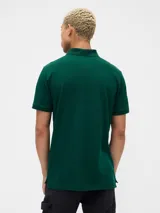 Chomba de hombre color bordó con cuello polo, manga corta y logo bordado de un oso en el pecho.