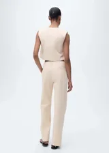 Pantalón de vestir color beige, de tiro medio y corte recto. Confeccionado en algodón con forro interior de poliéster. Presenta trabillas, dos bolsillos laterales y cierre oculto de botón, gancho y cremallera.