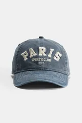 Gorra de algodón color azul denim con visera curva y bordado frontal con la inscripción "Paris Sports Club 1972".