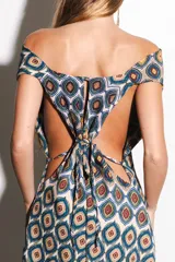 Vestido largo con estampado étnico y escote pronunciado en los laterales, diseñado para ser fluido y fresco.