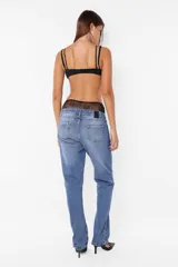 Microtop lencero negro con superposiciones de encaje y microfibra liviana, acceso delantero mediante un avío de encastre, breteles ajustables y terminaciones con elástico partido.