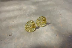 Aros tipo botón dorados con textura irregular que simula la superficie de un molusco.