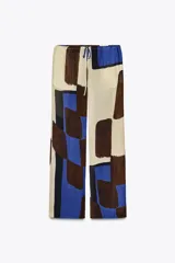 Pantalón de viscosa con estampado abstracto en tonos beige, azul y marrón. Tiene tiro medio, cintura ajustable con cordones y pierna recta.