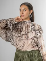 Camisa de seda italiana con estampado sutil de animal print en tonos tierra y beige. Diseño reversible con lazo que puede usarse en la espalda o al frente. Presenta volados en los hombros y mangas largas.