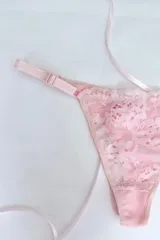 Tanga de tiro medio confeccionada en puntilla elastizada color rosado, con cola en algodón elastizado. Los costados son regulables y el fundillo es de algodón 100%.