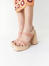 Sandalias de plataforma color naranja con detalles en marrón. Tienen tiras anchas sobre el empeine y el tobillo, y un tacón cuadrado alto.