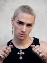 Collar plateado con cadena de eslabones gruesos y dije de cruz ornamentada con strass.