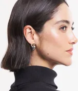 Par de aros colgantes con forma de corazón y lazo. Uno dorado con lazo plateado y otro plateado con lazo dorado.