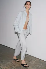 Pantalón culotte color crudo, de tiro medio, cintura elástica ajustable con cordones y bolsillos laterales ocultos en la costura.