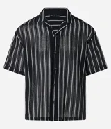 Camisa masculina modelo boxy, confeccionada en punto, con cuello polo, manga corta, cierre por botones y estampa de rayas verticales blancas sobre fondo negro.