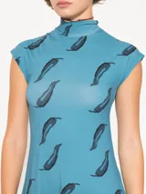 Vestido midi celeste con estampado de plumas negras, cuello alto y mangas cortas.
