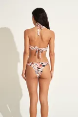 Top de bikini bandeau con estampado floral en tonos rosa y negro, con detalle de aro metálico en el centro y tiras halter.