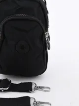 Bandolera negra de tela impermeable con correa ajustable, bolsillo frontal con cierre y asa de mano.