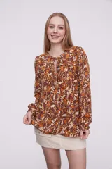 Blusa de viscosa con estampado floral en tonos cálidos, de corte holgado y manga larga.