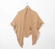 Ruana color beige de tejido de punto con detalle de trenzas y flecos en el borde. Incluye cinturón de cuero sintético marrón con hebilla dorada.